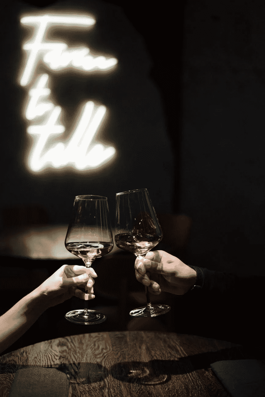 Two people toasting wine glasses