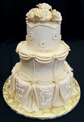 A cream-colored wedding cake with white decals.