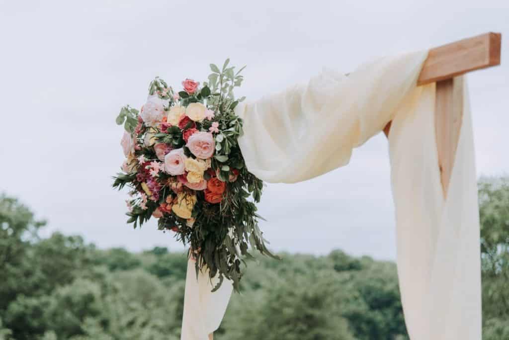 Flowers and cloth draped over a wooden plaque at a wedding